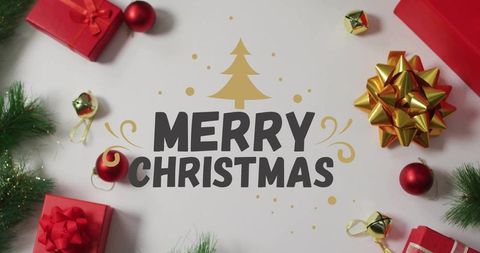 Merry christmas flatlay with gold tree graphic, red gifts, gold bow, jingle bells and pine
