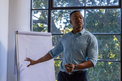 African american man presenting data on flipchart in bright office