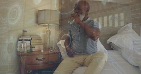 Senior man drinking water and checking medication while sitting on bed with digital health hud