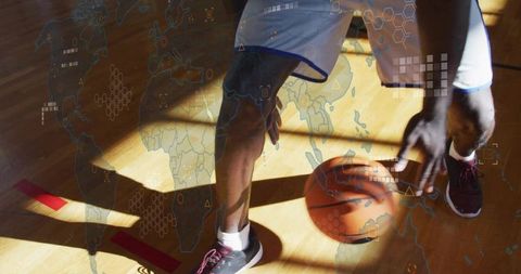 Dribbling basketball player on sunlit gym floor with hex grid and world map data overlay