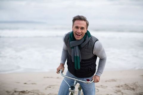 Man Enjoying Coastal Bike Ride on Sandy Beach