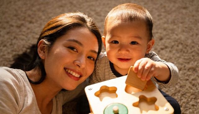 Parent and toddler bonding while playing with wooden shape sorter on cozy carpet at home