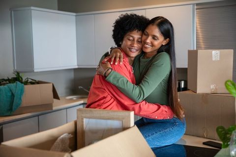 Couple Embraces While Unpacking in New Home Kitchen