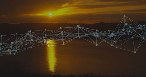 Digital Network Glowing Over Lakeshore with Sunset Reflection