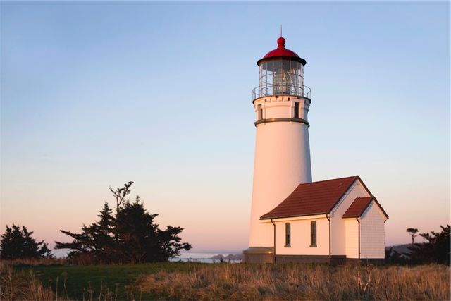 Historic White Lighthouse amid Coastal Landscape at Sunset - Download Free Stock Images Pikwizard.com