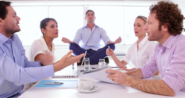 Office Meeting with Man Meditating on Desk in Background - Download Free Stock Images Pikwizard.com