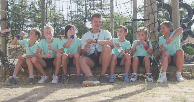 Coach Taking a Break with Young Kids on Adventure Playground - Download Free Stock Images Pikwizard.com