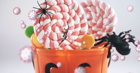 Halloween candy with spiders and virus symbols floating around