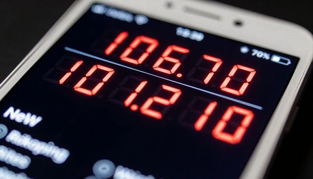 Smartphone displaying red seven-segment numeric readouts and battery icon closeup