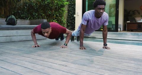 Diverse Friends Doing Push-Ups Together Outdoors With Fitness Watches