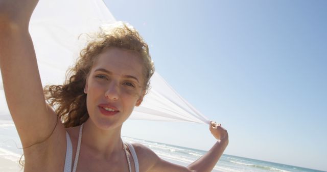 Joyful Young Woman Enjoying Sunny Beach Day with White Scarf - Download Free Stock Images Pikwizard.com