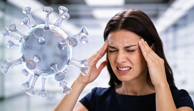 Woman experiencing headache while 3d coronavirus model hovering in clinical corridor