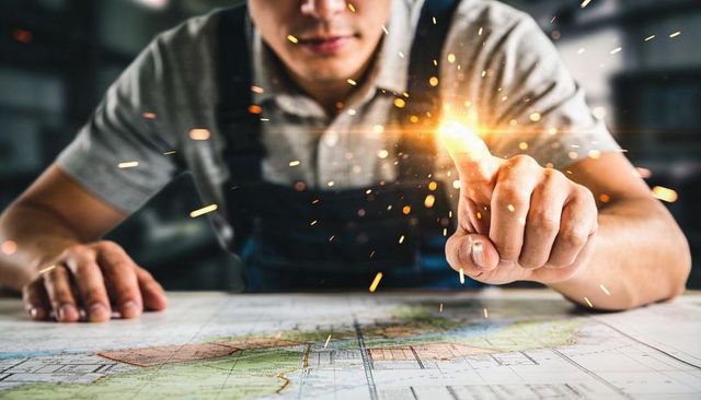 Engineer touching glowing point on blueprint with sparks highlighting precision innovation