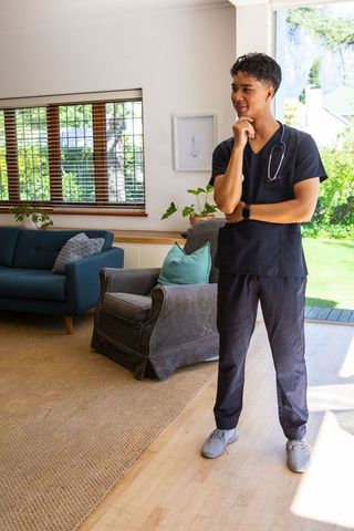 Healthcare professional standing at home bright interior