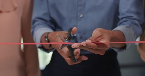 Business Team Cutting Red Ribbon in Office Ceremony