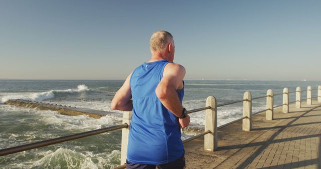 Senior man jogging along ocean promenade enjoying morning exercise - Download Free Stock Images Pikwizard.com