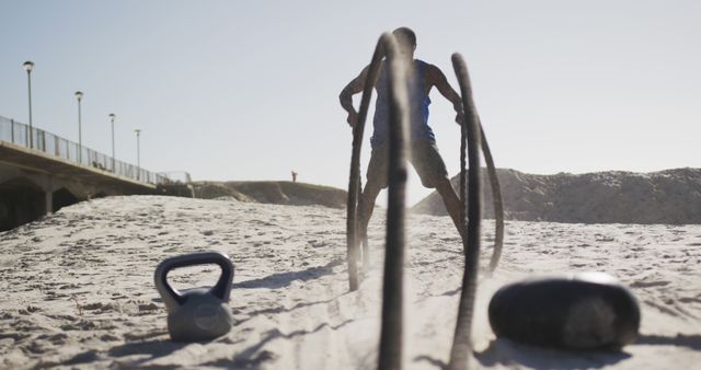 Man Engaging in Intense Beach Workout with Battle Ropes - Download Free Stock Images Pikwizard.com