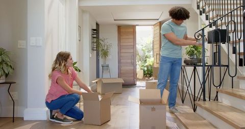 Couple Unpacking Boxes in New Home Interior, Starts Journey with Happiness