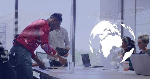 Business team collaborating around conference table with digital globe overlay and laptops