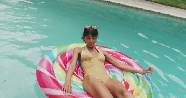 Woman on colorful pool float enjoying summer relaxation - Download Free Stock Images Pikwizard.com