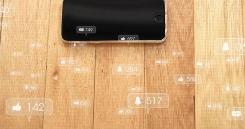 Modern Smartphone Receiving Social Media Likes Comments and Alerts on Wood Surface