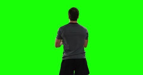 Man standing against green screen for creative media editing