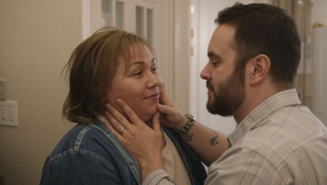 Tender couple holding cheeks in cozy home hallway, intimate romantic moment, affection