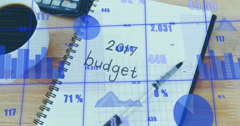 Planning 2017 budget with notebook calculator coffee pen and financial charts overlay