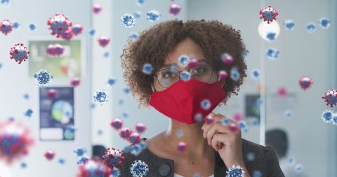 Office worker wearing mask with overlay of covid-19 cells