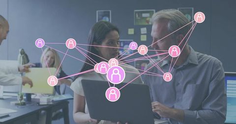 Collaborating office team using laptop with pink social network overlay for teamwork