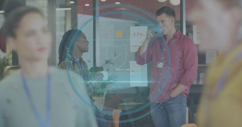 Coworkers chatting over coffee at glass partition with blue circular digital overlay