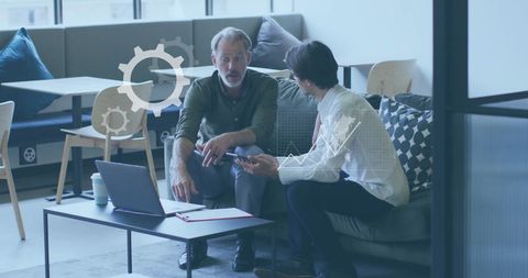 Colleagues discussing technology with digital data overlay in modern office