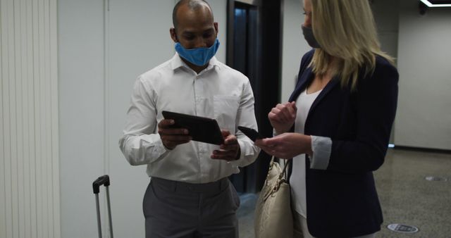 Diverse Business Professionals Discussing Work on Digital Tablet in Office Corridor - Download Free Stock Images Pikwizard.com