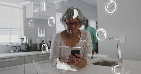 Senior woman checking smartphone with augmented reality analytics in modern kitchen