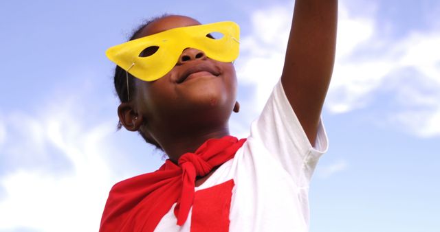 Joyful Child in Superhero Costume Raising Arm Under Blue Sky - Download Free Stock Images Pikwizard.com