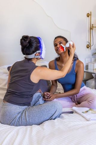 At-home led facial session applying red light therapy device for glowing skin and wellness