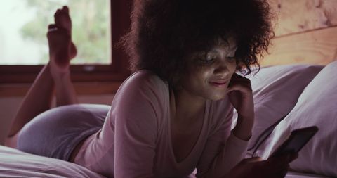 Young Woman Relaxing at Home with Smartphone on Bed - Download Free Stock Images Pikwizard.com