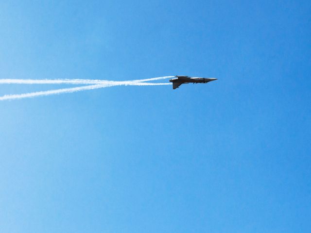 Jet Fighter Soaring in Clear Blue Sky with Vapor Trails - Download Free Stock Photos Pikwizard.com