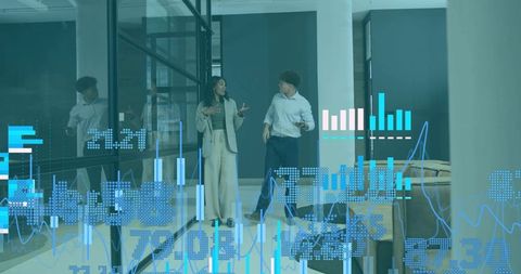 Business professionals walking and discussing data visualization through glass corridor