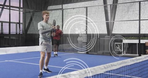 Young athletes training on indoor padel court holding racket with hud overlay graphics