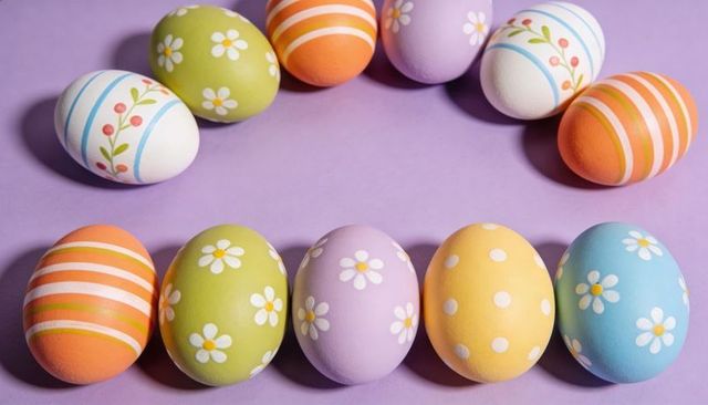 Arranging Pastel Easter Eggs in Symmetrical Rows on Lavender Surface