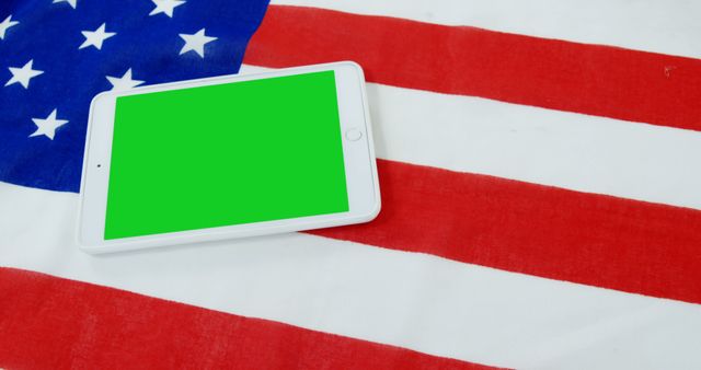 Tablet with blank green screen on American flag background evoking themes of technology and patriotism. Suitable for illustrating tech developments in the USA, concepts of digital integration in national contexts, or advertisements merging modern tech with patriotic elements.