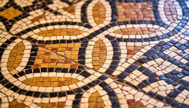 Tessellated mosaic floor with interlocking rings and ovals in ochre black and white tiles