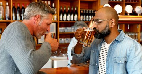 Friends Relaxing over Beer at Cozy Bar Setting