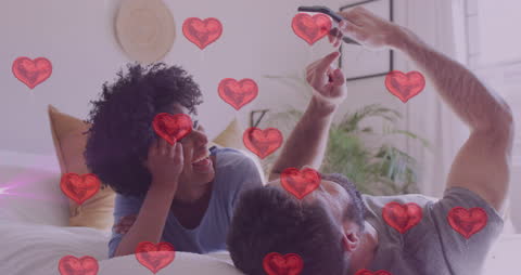 Romantic Couple Relaxing on Bed with Smartphone Hearts Animation