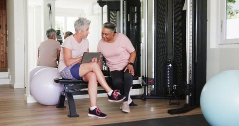 Senior Lesbians Engaging with Technology at Home Gym