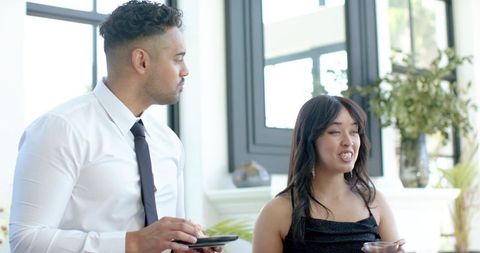 Young professionals networking at corporate reception with drinks and small plates