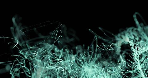 Green light trails on black background in seamless loop