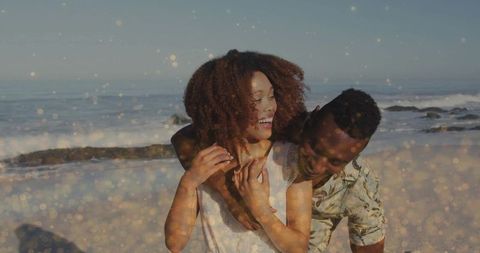 Smiling Couple Embracing at Beach with Waves under Sunlight
