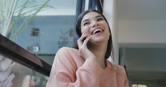 Smiling Young Woman Talking on Smartphone by Window - Download Free Stock Images Pikwizard.com